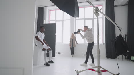 photographer-is-capturing-professional-football-player-with-ball-in-studio-content-for-magazine